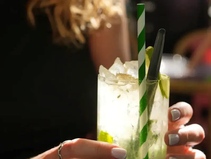 Mojito rafraîchissant préparé avec du rhum blanc, des feuilles de menthe fraîches et du citron vert, servi en terrasse d'un restaurant à la Place d'Italie, Paris 13e.