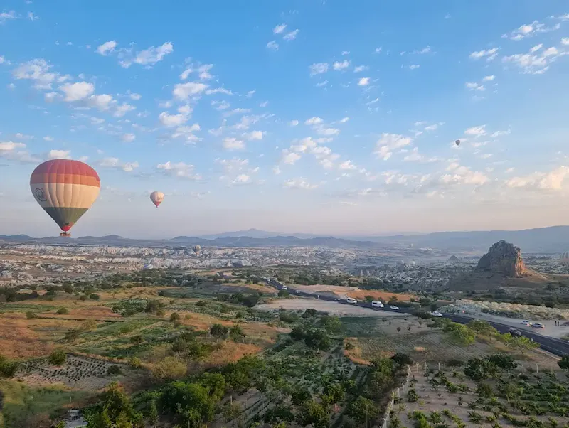 two hot air balloons flying over a city | Photo de World Wanderer, sur https://unsplash.com/@worldwanderer2024?utm_source=centralapp&utm_medium=referral