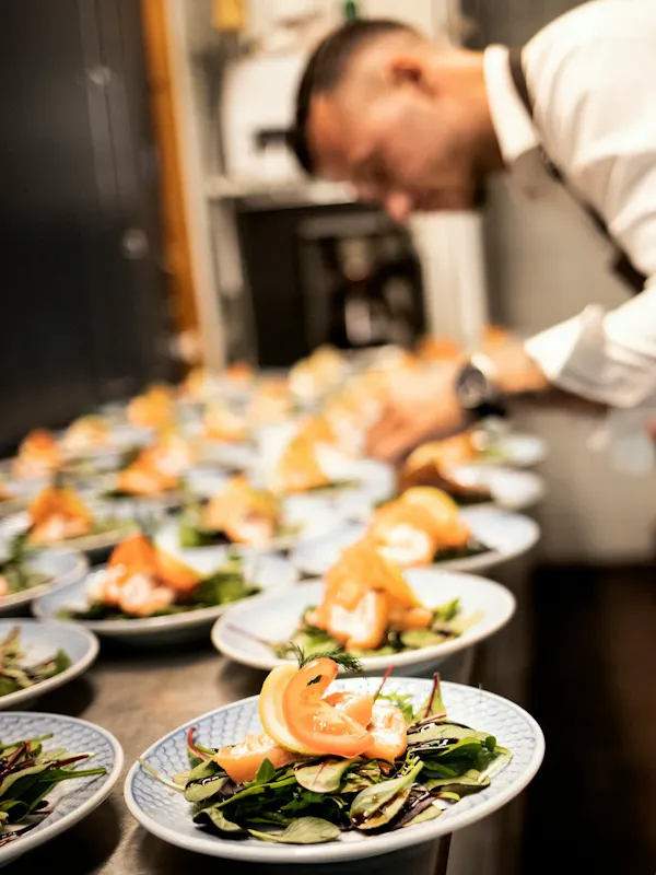 a chef preparing food on plates in a kitchen | Photo de Filip Rankovic Grobgaard, sur https://unsplash.com/@filipgrobgaard?utm_source=centralapp&utm_medium=referral