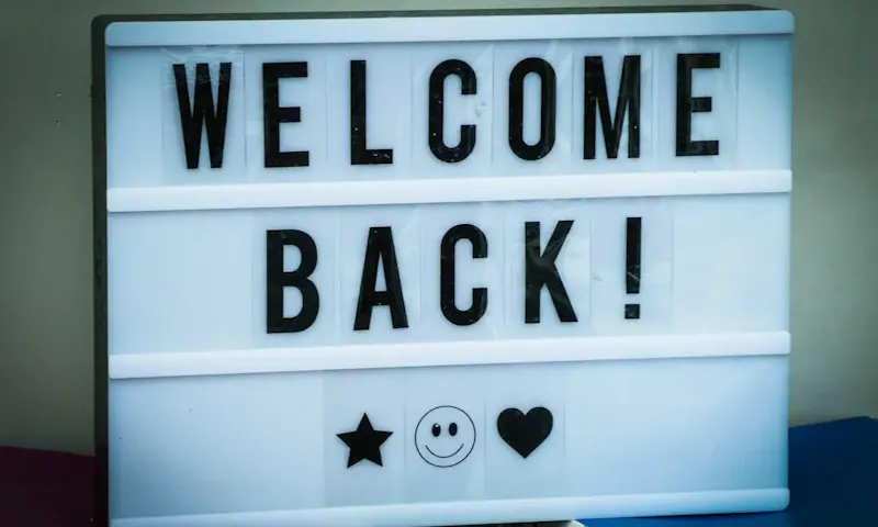 Foto di La Pâte et Ose a welcome back sign with a smiley face | Immagine di Nick Fewings, su https://unsplash.com/@jannerboy62?utm_source=centralapp&utm_medium=referral