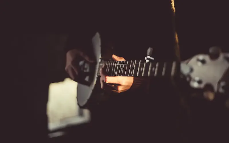 person playing banjo inside dark room | Photo by Priscilla Du Preez 🇨🇦, on https://unsplash.com/@priscilladupreez?utm_source=centralapp&utm_medium=referral