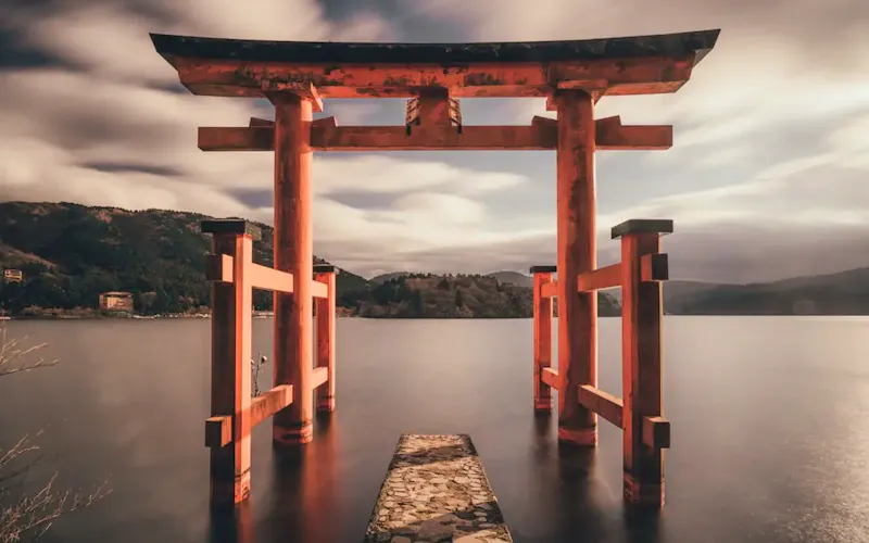 Foto von La Cantoniera A red torii gate standing in the water at Lake Ashi in Hakone, Japan. | Bild von Tianshu Liu, auf https://unsplash.com/@tianshu?utm_source=CentralApp&utm_medium=referral