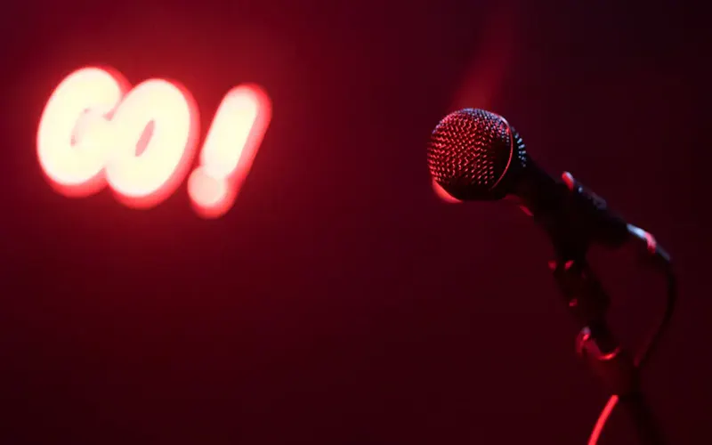 Photo de Vertigo Microphone on stage with glowing red 'GO!' sign, perfect for nightlife themes. | Photo de Teemu R, sur https://www.pexels.com/@teemu-r-555088?utm_source=centralapp&utm_medium=referral