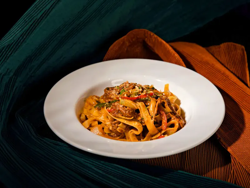 Image of Hostaria di pantaneto 55 A mouthwatering dish of homemade tagliatelle with vibrant vegetables on a stylish background. | Photo by Change C.C, on https://www.pexels.com/@change-c-c-974768353?utm_source=CentralApp&utm_medium=referral