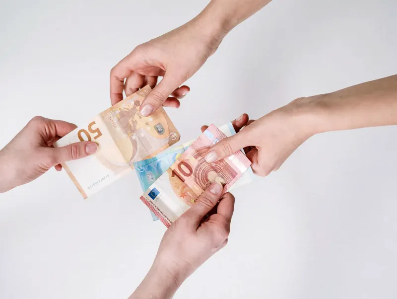 Two pairs of hands exchanging Euro banknotes, symbolizing finance and transaction. | Photo by cottonbro studio, on https://www.pexels.com/@cottonbro?utm_source=CentralApp&utm_medium=referral