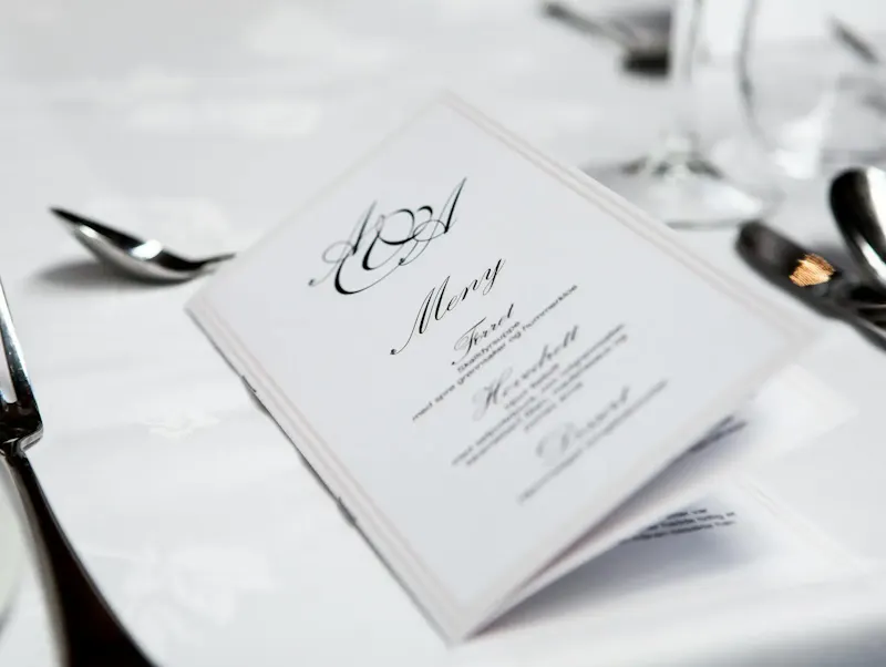 Close-up of a refined dining table with menu and silverware, showcasing elegance in a formal restaurant setting. | Immagine di Terje Sollie, su https://www.pexels.com/@solliefoto?utm_source=centralapp&utm_medium=referral