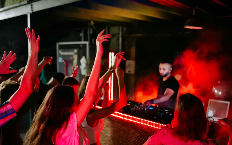 Image of Moksha Vibrant nightclub atmosphere with a DJ playing music and crowd enjoying the night. | Photo by Yan Krukau, on https://www.pexels.com/@yankrukov?utm_source=centralapp&utm_medium=referral