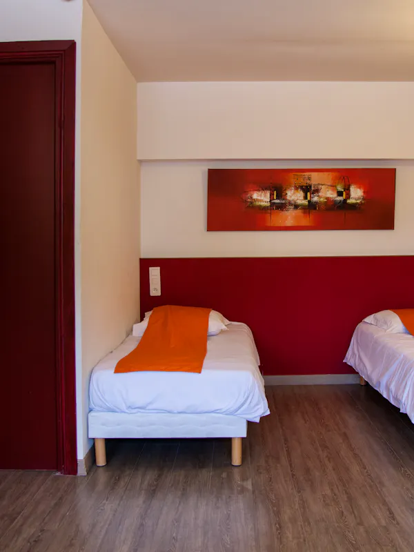 Chambre confortable pour trois personnes, équipée de trois lits simples ou d’un lit simple et d’un lit superposé, avec salle de bain et toilettes privatives. Petit-déjeuner inclus.
