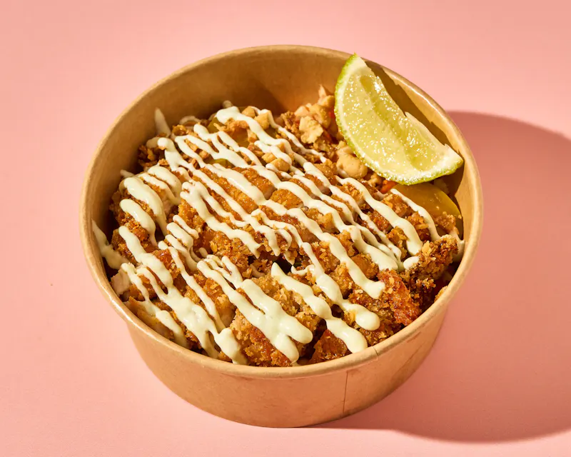 Crispy Chicken Bowl de Buns: poulet frit mariné au Saté, crudités croquantes, cacahuètes, oignons crispy et mayonnaise maison au wasabi.