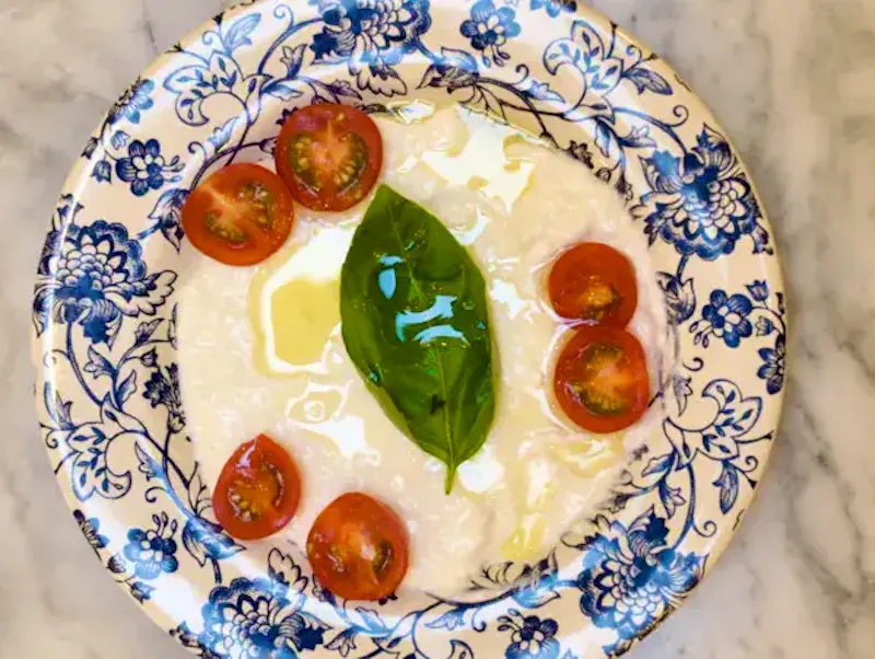 Assiette de Stracciatella fondante et crème de burrata onctueuse servie chez Ti Amo Châtelet. Une entrée italienne généreuse, idéale à partager en plein centre de Paris, accompagnée de pain artisanal croustillant.