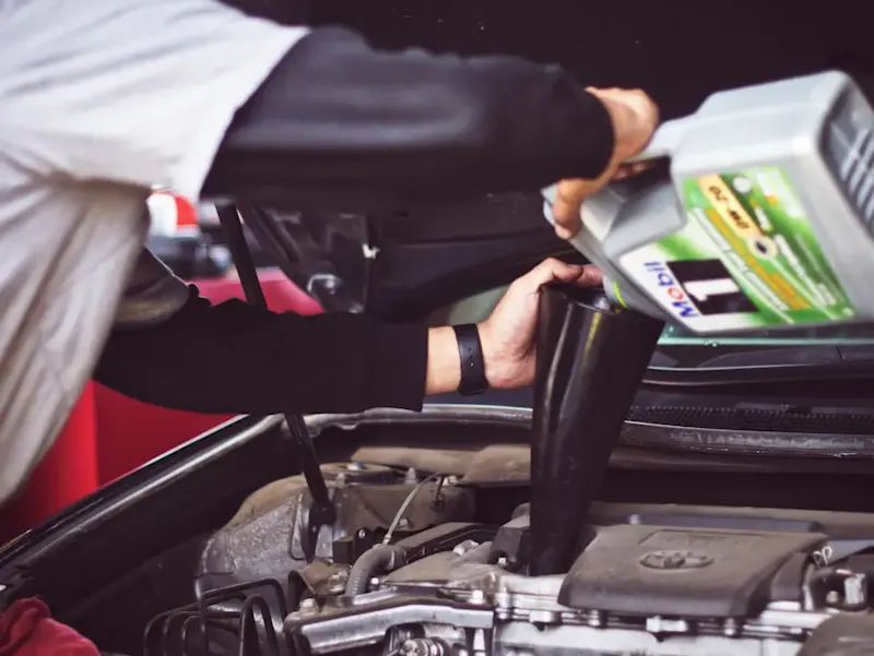 man refilling motor oil on car engine bay | Photo de Tim Mossholder, sur https://unsplash.com/@timmossholder?utm_source=centralapp&utm_medium=referral