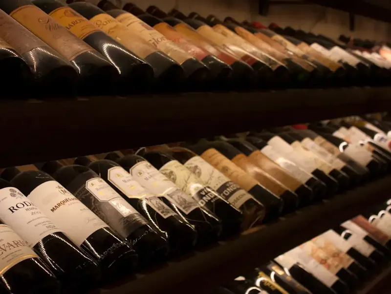 Image of Relais Saint Christophe black and white bottles on brown wooden shelf | Photo by Javier Balseiro, on https://unsplash.com/@javier_balseiro?utm_source=centralapp&utm_medium=referral