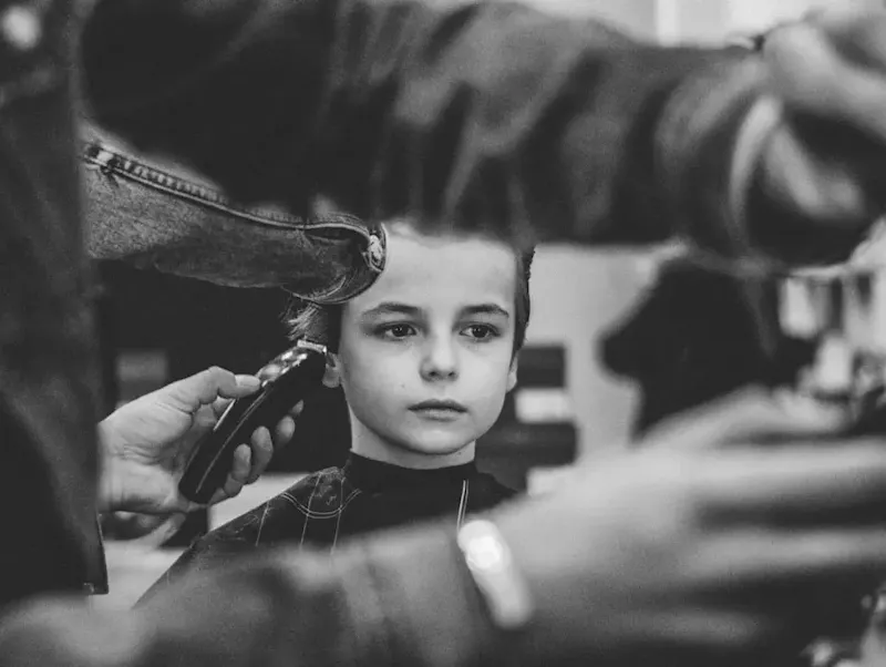 grayscale photo of boy having haircut | Photo de Tommy van Kessel, sur https://unsplash.com/@tommyvankessel?utm_source=centralapp&utm_medium=referral