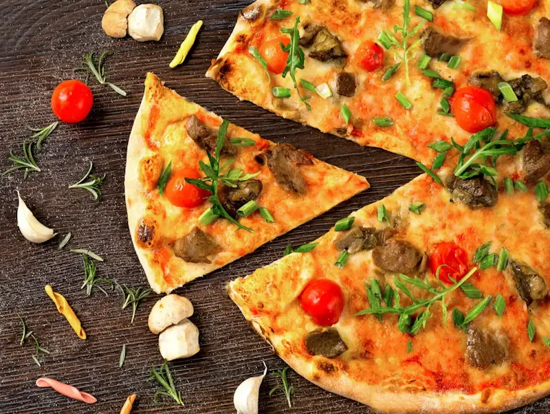 pizza with tomato and green leaves on white ceramic plate | Foto door Vit Ch, op https://unsplash.com/@v_uk_europe?utm_source=centralapp&utm_medium=referral