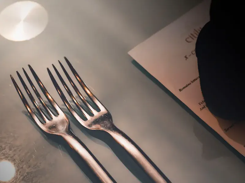 silver fork on white paper | Foto de motomoto sc, en https://unsplash.com/@motomotosc?utm_source=centralapp&utm_medium=referral