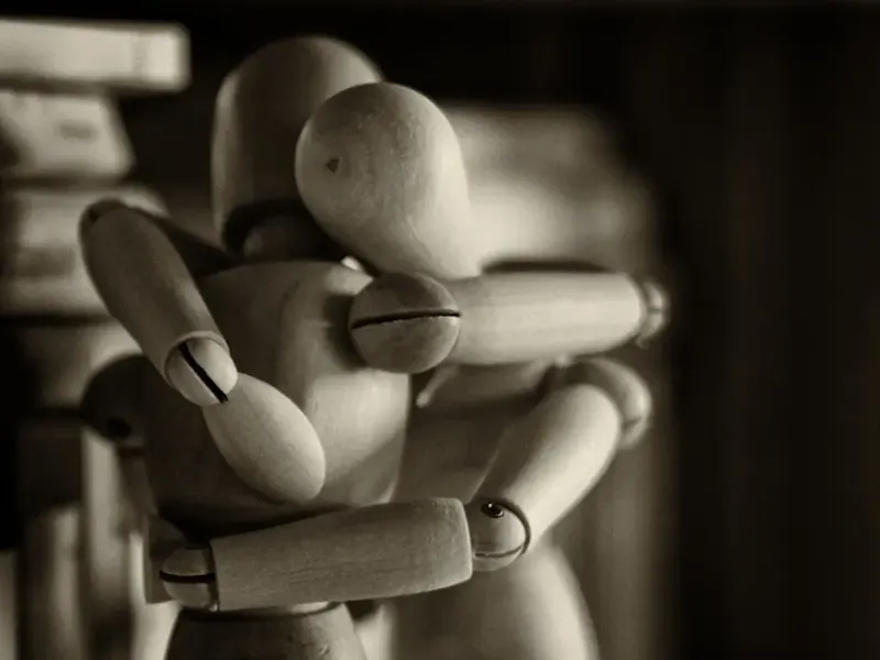 two wooden dummy hugging figures | Photo de Marco Bianchetti, sur https://unsplash.com/@marcobian?utm_source=centralapp&utm_medium=referral