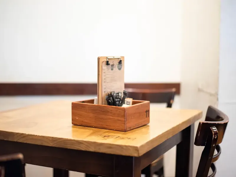 brown wooden rack on table with chairs | Photo by Sophie Elvis, on https://unsplash.com/@thetechnomaid?utm_source=centralapp&utm_medium=referral